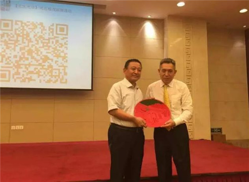 李其教授亲手将北京大学标志性的北大西门漆雕工艺礼品赠与跃迪集团董事长吕洪涛